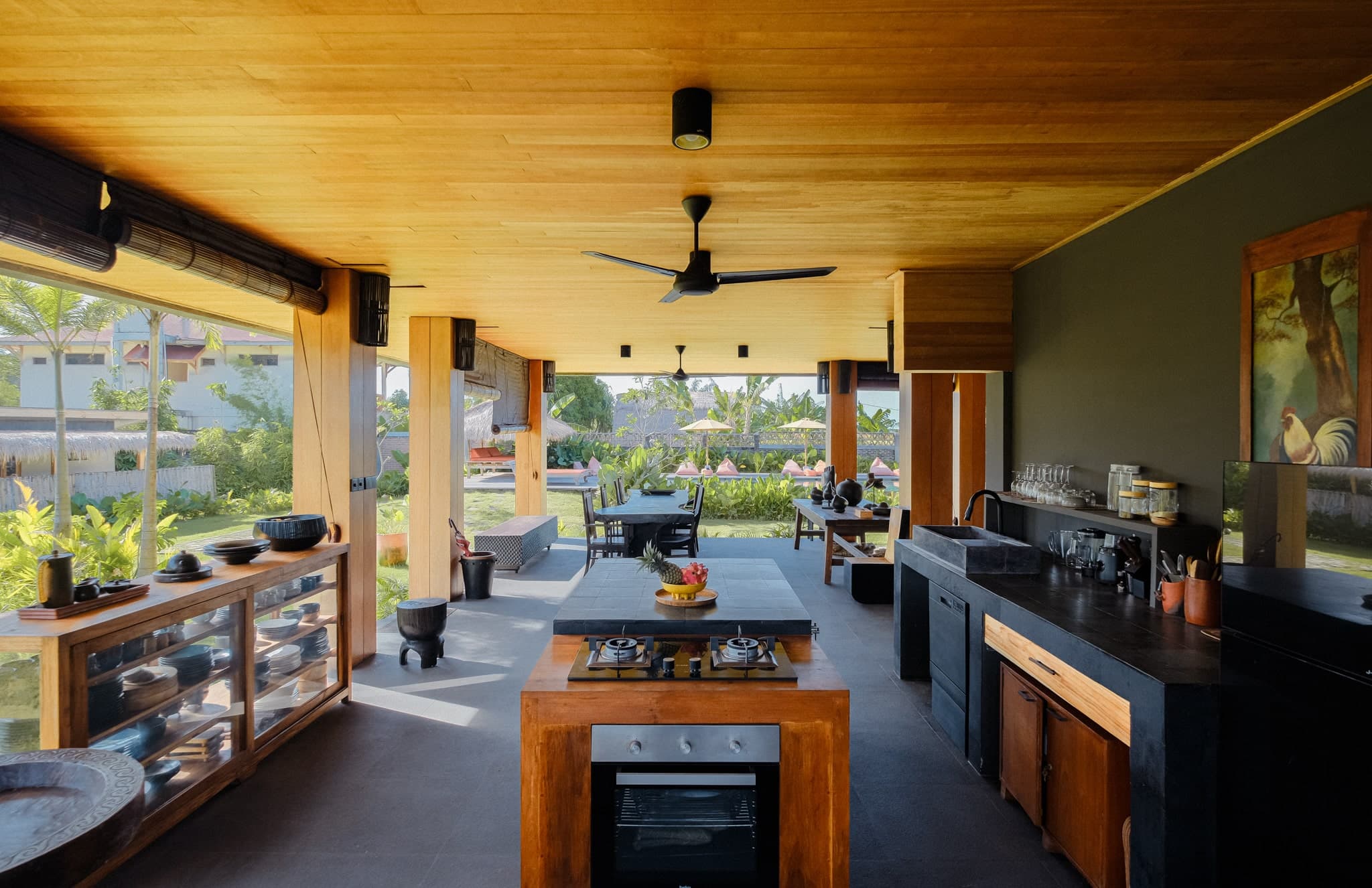 Open-air kitchen and dining area at Villa Gudea in Lombok, Indonesia – Featuring modern appliances, wooden finishes, tropical garden views, and a spacious layout for luxury living and entertaining