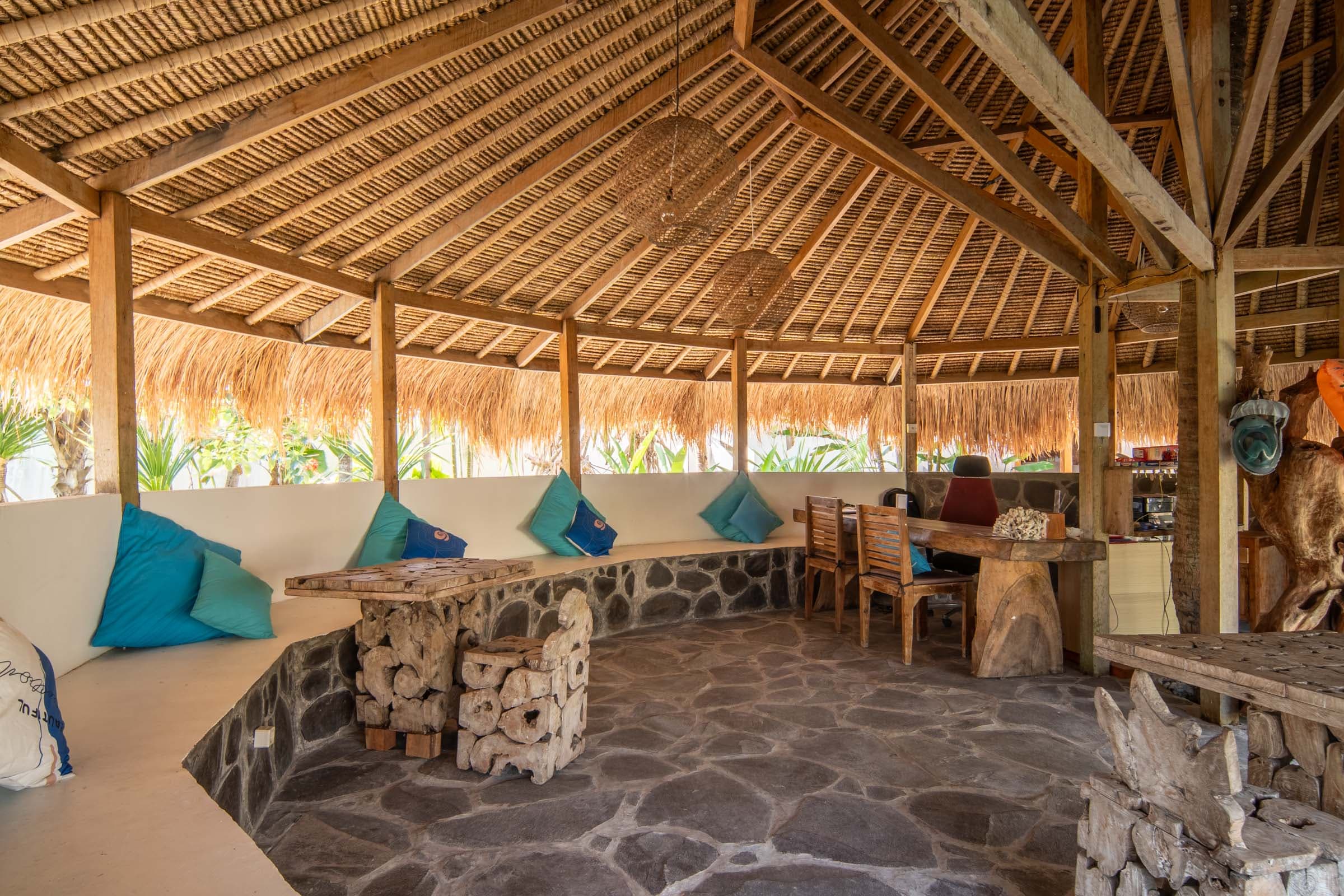 The reception area of Tiki Lodge, showcasing a blend of traditional Indonesian art and modern design elements, creating a warm and welcoming atmosphere for arriving guests