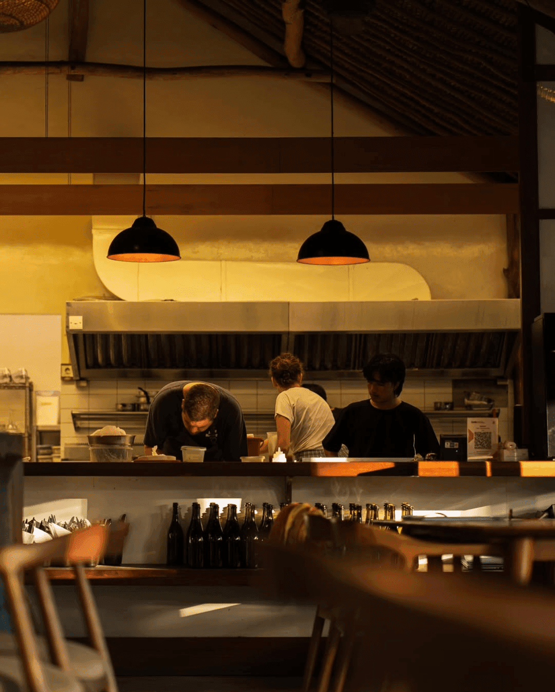 Cooks working in an open kitchen preparing for the night